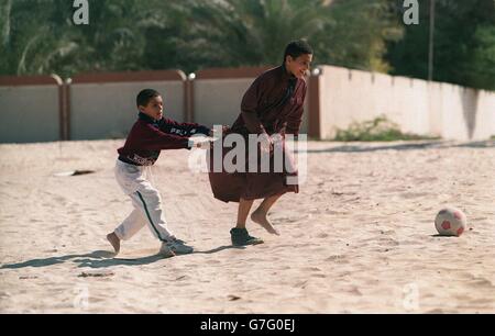 Kinder spielen Sport in Dubai, Vereinigte Arabische Emirate. Kinder spielen Fußball im Sand in Duabi Stockfoto