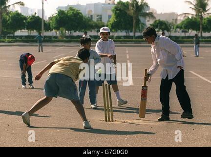 Kinder spielen Sport in Dubai, Vereinigte Arabische Emirate. Kinder spielen Cricket in den Straßen von Dubai Stockfoto