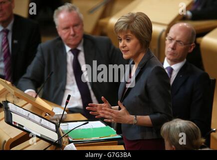 Schottlands erste Ministerin Nicola Sturgeon mit Finanzsekretär John Swinney (rechts) und Gesundheitssekretär Alex Neil (links) während ihres Debüts First Minster's Questions (FMQ's) in der Debattierkammer des schottischen Parlaments in Edinburgh, nachdem sie das Amt des ehemaligen Führers Alex Salmond übernommen hatte. Stockfoto