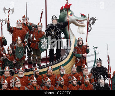 Mitglieder der Jarl Squad in Wikingerkostümen mit einer Wikingergaleere in Lerwick auf den Shetland Inseln während des Up Helly AA Viking Festivals. Stockfoto