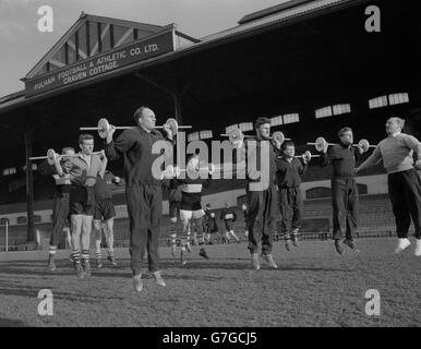 League Division Two - Fulham - Training - Olympic Coach Al Murray (ganz rechts) trainiert eine Gruppe von Fulham Fußballern, die im Craven Cottage, London, mit Gewichten trainieren. Der Verein hofft, dass Gewichtheben ihnen helfen kann, die höchste Fitness zu erreichen. In der Mitte befindet sich Jimmy Hill (mit Bart). Stockfoto