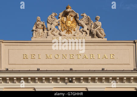 Geschnitzte Wappen, Wappen, Fabeltiere und Allegorien auf dem Dach ein barockes Gebäude in Wien (Österreich). Stockfoto