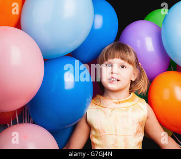 Studio-Porträt der kaukasischen blondes Mädchen mit bunten Luftballons auf schwarz Stockfoto