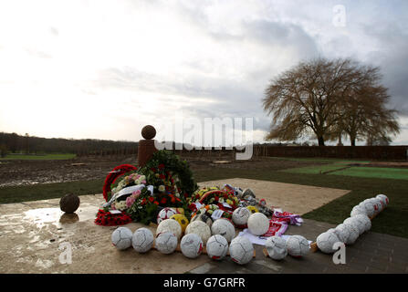 Kränze liegen gegen ein UEFA-Fußballdenkmal in Ploegsteert, Belgien, anlässlich des 100. Jahrestages des Weihnachtsfrieden zwischen deutschen und alliierten Truppen während des Ersten Weltkriegs, der während einer früheren Zeremonie von UEFA-Präsident Michel Platini und Gilbert Eleu, Bürgermeister von Comines-Warneton, enthüllt wurde. Stockfoto