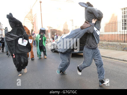 Die Teilnehmer Rennen während des jährlichen Londoner Pantomime Horse Race in Greenwich, um Geld für das Demelza Children's Hospice, London, zu sammeln. Stockfoto