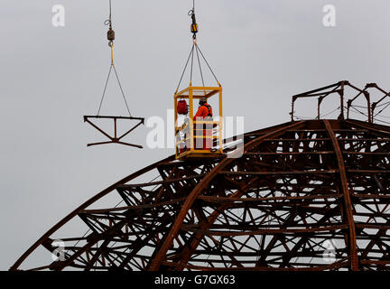 Demolition Spezialisten durchschneiden die Stahlkarkasse des Eastbourne Pier in East Sussex, als die Arbeiten beginnen, die kuppelförmige Spielhalle an der Vorderseite des viktorianischen Pier abzubauen, die im Sommer von einem Feuer verwüstet wurde. Stockfoto