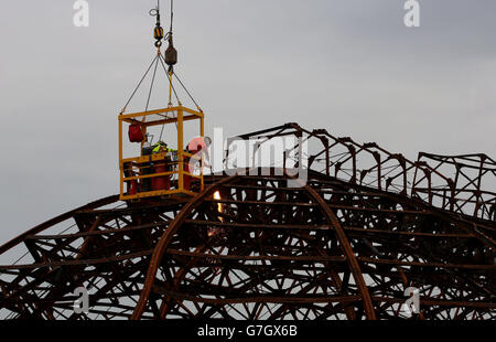 Demolition Spezialisten durchschneiden die Stahlkarkasse des Eastbourne Pier in East Sussex, als die Arbeiten beginnen, die kuppelförmige Spielhalle an der Vorderseite des viktorianischen Pier abzubauen, die im Sommer von einem Feuer verwüstet wurde. Stockfoto