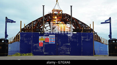 Demolition Spezialisten durchschneiden die Stahlkarkasse des Eastbourne Pier in East Sussex, als die Arbeiten beginnen, die kuppelförmige Spielhalle an der Vorderseite des viktorianischen Pier abzubauen, die im Sommer von einem Feuer verwüstet wurde. Stockfoto