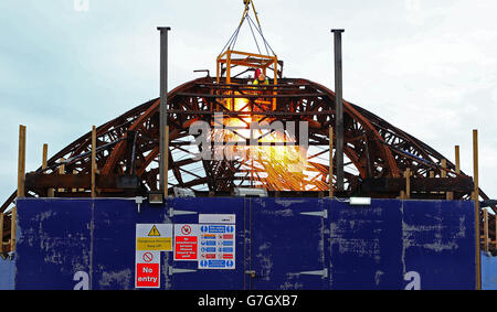 Demolition Spezialisten durchschneiden die Stahlkarkasse des Eastbourne Pier in East Sussex, als die Arbeiten beginnen, die kuppelförmige Spielhalle an der Vorderseite des viktorianischen Pier abzubauen, die im Sommer von einem Feuer verwüstet wurde. Stockfoto