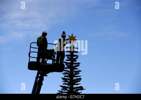 Modellbauer Katrina James (rechts) platziert einen LEGO Stern auf einem acht Meter hohen Weihnachtsbaum aus 300,000 Steinen im Legoland Windsor Resort in Berkshire. Stockfoto