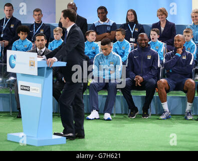 Manchester City Academy Coach, Patrick Vieira (2. Rechts) und Captain, Vincent Kompany (rechts) als Kanzler betrachtet, spricht George Osbourne das Publikum zur Eröffnung des Etihad Campus (City Football Academy) an. Manchester. Stockfoto