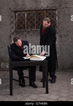 Premierminister David Cameron unterschreibt das Gästebuch vor einer Gaskammer des Konzentrationslagers Auschwitz in Polen, als Teil eines persönlichen Besuchs, den er zum ersten Mal seit seiner Zeit als Premierminister in den ehemaligen Konzentrationslagern Auschwitz und Birkenau machte. Stockfoto