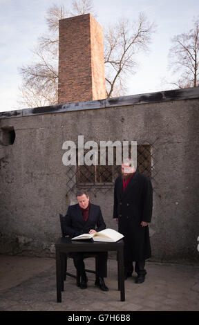 Premierminister David Cameron unterschreibt das Gästebuch vor einer Gaskammer des Konzentrationslagers Auschwitz in Polen, als Teil eines persönlichen Besuchs, den er zum ersten Mal seit seiner Zeit als Premierminister in den ehemaligen Konzentrationslagern Auschwitz und Birkenau machte. Stockfoto