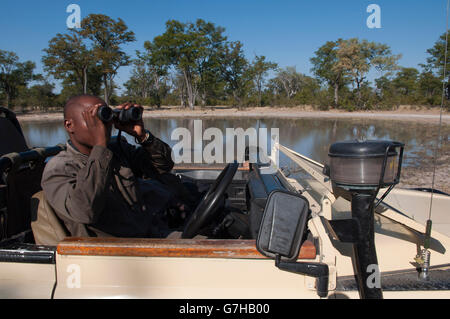 Mann mit Fernglas, Savute Kanal, Linyanti, Botswana, Afrika Stockfoto