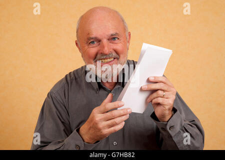 Älterer Mann, 59, mit Brief, Rechnung, lachen, Freude Stockfoto