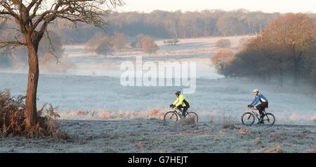 Radfahrer machen sich den Weg durch den Richmond Park im Südwesten Londons, da ein Großteil Großbritanniens nach einem frostigen Morgen aufwachte. Stockfoto