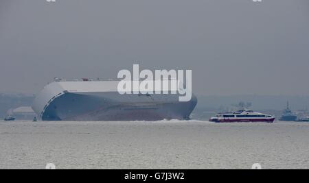 Eine Red Funnel Red Jet Hi-Speed Fähre fährt an der Hoegh Osaka, einem Autoträger, vorbei, nachdem das Schiff auf der Bramble Bank im Solent zwischen Southampton und der Isle of Wight gestrandet ist. Stockfoto