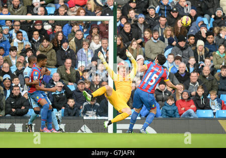 Joe Hart von Manchester City (zweite rechts) rettet einen Schuss von Crystal Palace's Mile Jedinak während des Spiels der Barclays Premier League im Etihad Stadium, Manchester. Stockfoto