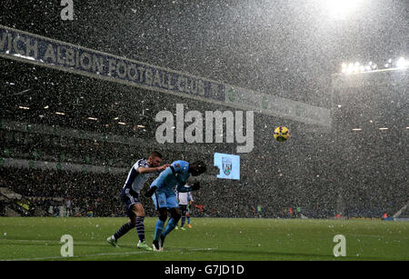 Bacary Sagna von Manchester City steht während des Spiels der Barclays Premier League auf den Hawthorns in West Bromwich über James Morrison von West Bromwich, Albion, im Schnee. Stockfoto