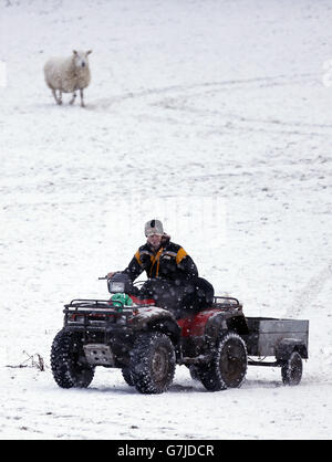 Ein Landarbeiter in der Nähe des Balmoral Estate, Aberdeenshire, als das winterliche Wetter Großbritannien überschwemmte, während Reisende als stark schneebedeckte Straßen gestrandet waren und zwei Flughäfen zur Schließung zwangen. Stockfoto