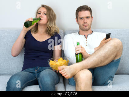 Mann und Frau Sportübertragungen im Fernsehen übereinstimmen. Stockfoto