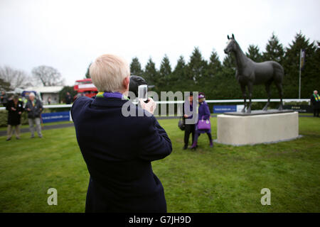 Pferderennen - 2014 William Hill Winter Festival - Tag 1 - Kempton Park. Die Fans lassen ihre Fotos mit der Kauto Star-Statue im Paradering auf der Rennbahn Kempton Park machen Stockfoto