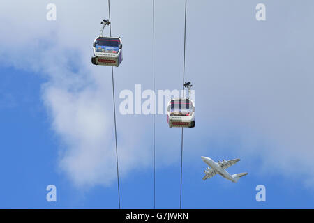 Ein Flugzeug startet vom Flughafen London City und geht über die TfL Emirates Air Line Seilbahn am Londoner Royal Docks Stockfoto