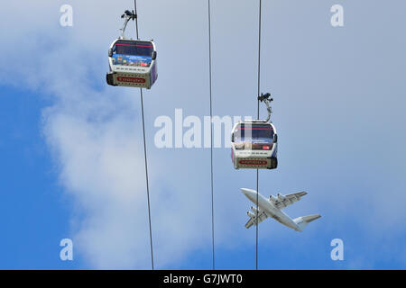 Ein Flugzeug startet vom Flughafen London City und geht über die TfL Emirates Air Line Seilbahn am Londoner Royal Docks Stockfoto