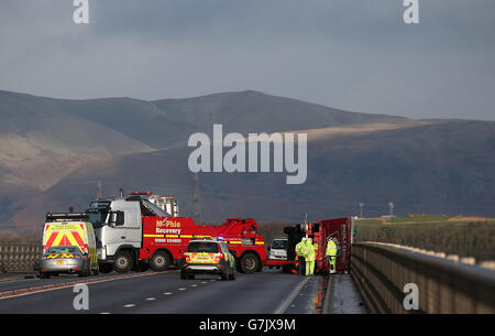 Ein Lastwagen liegt auf seiner Seite, nachdem er bei starkem Wind auf der Clackmannanshire Bridge über den Firth of Forth, Schottland, überwehen wurde, da starke Winde einen weiteren Tag der Störung der britischen Verkehrsnetze gebracht haben, während Warnungen vor heftigen Böen bestehen bleiben, Schnee und Eis über den Großteil des Wochenendes. Stockfoto