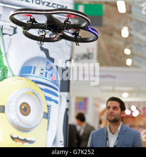 Ein Demonstrator, der den X-Bladez Stunt Quadcopter, ausgestattet mit einem Wasserwerfer und einem Raketenwerfer, während der Pressevorschau zur Spielwarenmesse 2015 in Olympia in London betreibt. Stockfoto