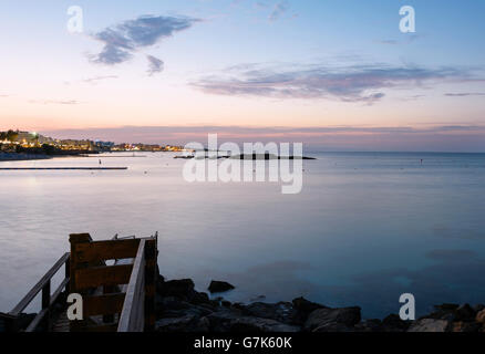 Foto des Meeres in Protaras, Zypern-Insel, mit Felsen und Hotels bei Sonnenuntergang. Stockfoto