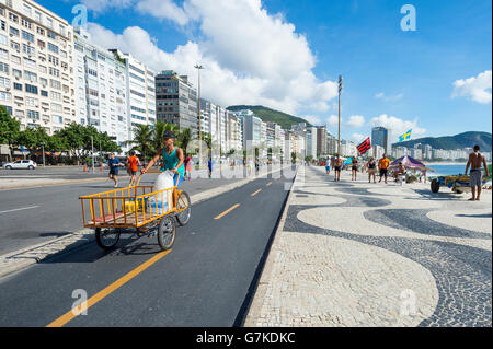 RIO DE JANEIRO - 3. April 2016: Street Lieferant liefert Säcke mit frischem Eis an Strand Stände von einem Wagen auf die Copacabana Strand boa Stockfoto