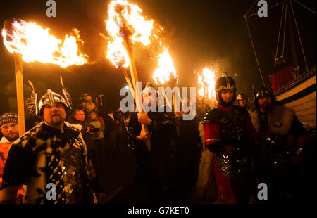 Mitglieder der Jarl-Truppe in Wikingerkostümen halten während des Up Helly AA Viking Festivals in Lerwick auf den Shetland Isles flammende Fackeln. Stockfoto