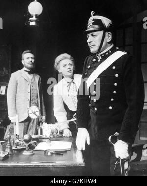 Der britische Schauspieler Sir Laurence Olivier (r), der Edgar spielt, in einer Szene aus der Wiederbelebung von August Strindbergs „Dance of Death“ in London durch die National Theatre Company. Ebenfalls in der Szene sind Robert Stephens (l.), der Kurt spielt, und Geraldine McEwan als Alice. Stockfoto