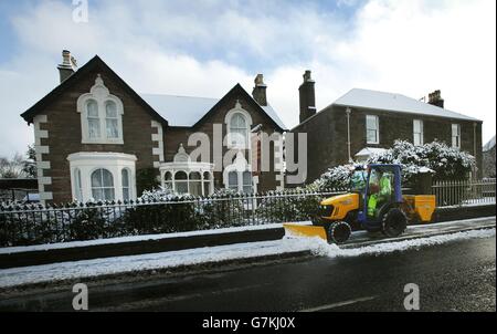 Schnee wird von einem Gehsteig in Blairgowrie geräumt, da Schnee Teile des Vereinigten Königreichs erneut stören kann. Stockfoto