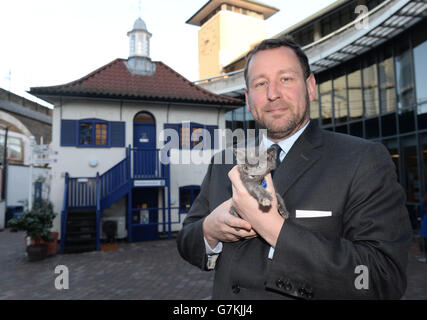 Der Minister für Kultur, Kommunikation und Kreativwirtschaft Ed Vaizey posiert mit Whittington, einem sieben Wochen alten Kätzchen, vor der Whittington Lodge, ursprünglich ein Zwingertier im Battersea Dogs &amp; Cats Home, das den Status eines Listed erhalten hat. Stockfoto