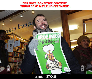 EDS-HINWEIS: SENSIBLE INHALTE, DIE EINIGE BELEIDIGEND FINDEN KÖNNEN. Ein Mann vor der französischen Buchhandlung in South Kensington, London, mit einer Kopie des französischen satirischen Magazins Charlie Hebdo. Stockfoto