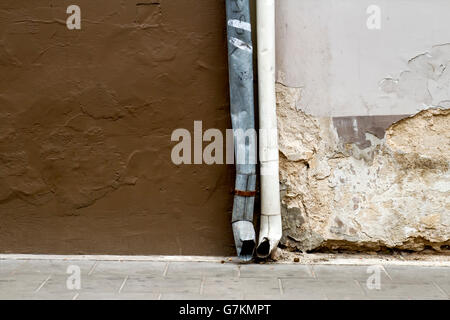 Alte beschädigte Wand und Regen Dachrinnen Hintergrund Textur Stockfoto