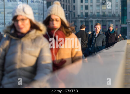 Pendler überqueren die London Bridge im Zentrum von London während der morgendlichen Hauptverkehrszeit. Stockfoto