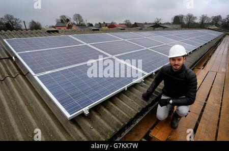 Joe Nixon von REPOWERBalcombe mit 69 Solarmodulen, die auf einem Kuhstall in der Nähe von Balcombe in West Sussex installiert wurden, Das erste kommunale Solarpaneelprojekt des Dorfes wird als Teil eines langfristigen Plans zur Erzeugung von genügend Strom für den gesamten Stromverbrauch des Dorfes abgeschlossen. Stockfoto