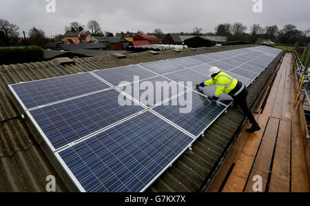 Leo Smith, Project Manager bei Southern Solar, führt die letzten Prüfungen von 69 Solarmodulen durch, die auf einem Kuhstall in der Nähe von Balcombe in West Sussex installiert wurden. Die Fertigstellung des ersten Solarpaneelprojekts im Gemeindebesitz ist Teil eines langfristigen Plans, um genügend Strom zu erzeugen, um den gesamten Stromverbrauch des Dorfes zu decken. Stockfoto