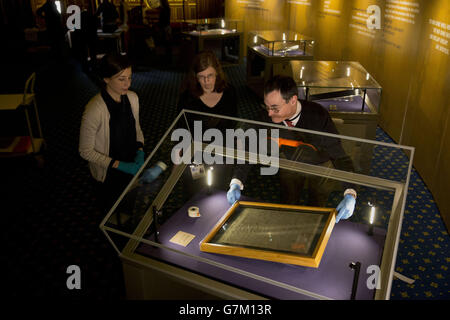 Die Salisbury Cathedral 1215 Kopie der Magna Carta wird in einem Schrank von Chris Woods (rechts), dem Direktor des National Conservation Service, installiert. Neben den anderen drei erhaltenen Originalumwingungen aus Pergament der Magna Carta anlässlich des 800. Jahrestages der Versiegelung der Magna Carta in Runnymede im Jahr 1215 im Robing Room der Queen im Houses of Parliament in London zu sehen. Stockfoto