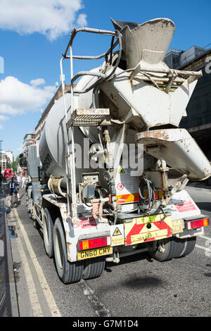 Ein Radfahrer wartet eine Ampel neben einen Betonmischer auf der Londoner Regent Street, UK Stockfoto