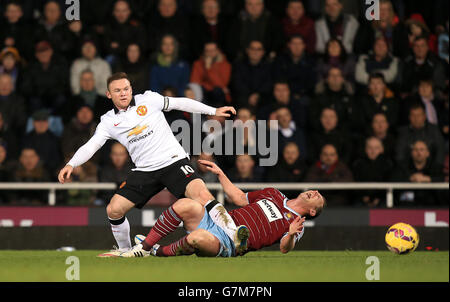 Wayne Rooney von Manchester United kämpft mit Kevin Nolan von West Ham United während des Spiels der Barclays Premier League im Upton Park in London um den Ball. Stockfoto