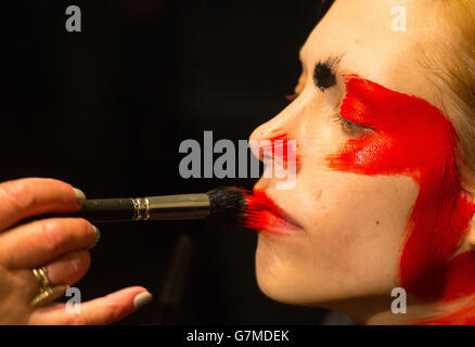 Ein Model lässt ihr Make-up hinter der Bühne aufbringen, bevor die Vivienne Westwood Red Label Herbst/Winter 2015 London Fashion Week im Science Museum in Kensington, West London, gezeigt wird. Stockfoto