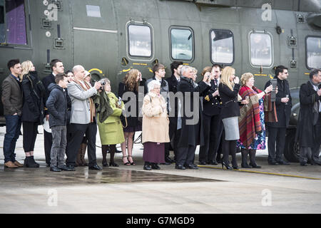 Die Menschen beobachten, wie der Hubschrauber Royal Navy Merlin nach einer "Wings"-Zeremonie, an der der Duke of York im Royal Naval Air Station Yeovilton, Somerset, teilnimmt, taktische Manöver durchführt. Stockfoto