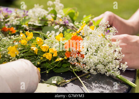 Frau macht eine schwedische Mittsommer-Kopf-Kreation. Stockfoto