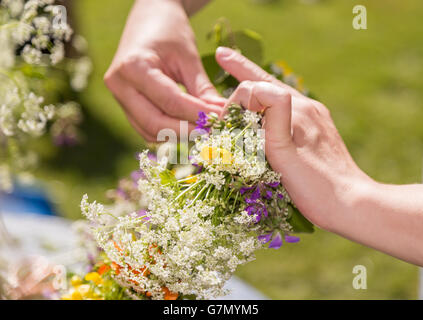 Frau macht eine schwedische Mittsommer-Kopf-Kreation. Stockfoto