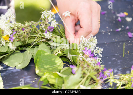 Frau macht eine schwedische Mittsommer-Kopf-Kreation. Stockfoto