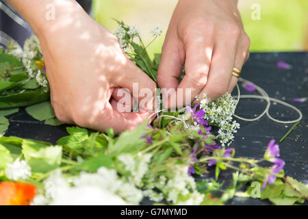 Frau macht eine schwedische Mittsommer-Kopf-Kreation. Stockfoto